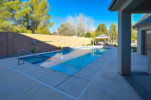 View of pool with a patio area and a gazebo