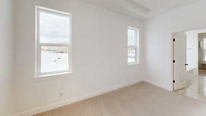 Unfurnished room featuring light carpet and baseboards