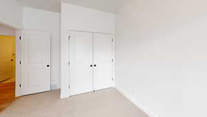 Unfurnished bedroom featuring light carpet, a closet, visible vents, and baseboards