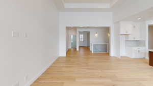 Interior space with light wood-style floors, a high ceiling, baseboards, and recessed lighting