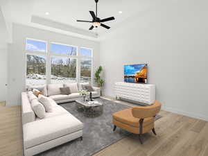 Living room featuring baseboards, recessed lighting, a ceiling fan, a raised ceiling, and light wood-style floors
