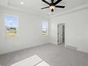 Unfurnished room with light carpet, visible vents, recessed lighting, and a raised ceiling