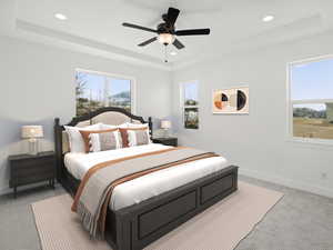 Bedroom featuring light carpet, a tray ceiling, and baseboards