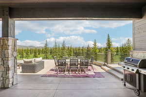 View of patio with outdoor dining space, a mountain view, and area for grilling