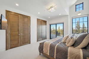 Bedroom with access to exterior, multiple windows, light carpet, and recessed lighting