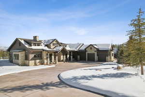 View of front of home with stone siding and a chimney