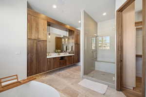 Bathroom featuring a stall shower, double vanity, and a freestanding tub