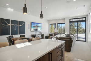 Kitchen featuring plenty of natural light, open floor plan, recessed lighting, pendant lighting, and light countertops