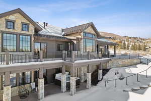 Snow covered rear of property with a mountain view