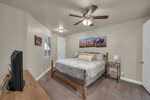 Carpeted bedroom featuring ceiling fan