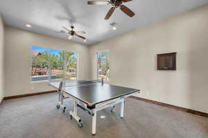 Recreation room with light carpet and ceiling fan