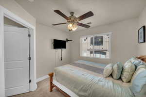 Carpeted bedroom featuring ceiling fan