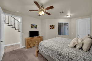 Carpeted bedroom featuring ceiling fan