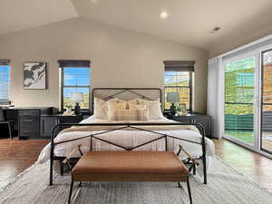 Bedroom with vaulted ceiling, access to exterior, and hardwood / wood-style flooring