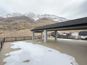 Snow covered patio featuring a mountain view