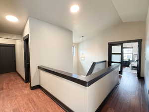 Hall with hardwood / wood-style floors and lofted ceiling