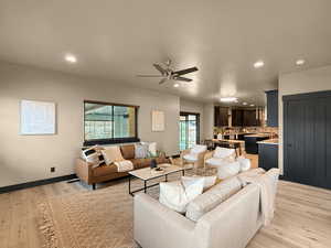 Living room featuring ceiling fan and light hardwood / wood-style flooring