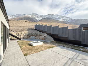 View of yard featuring an outdoor fire pit, a patio area, and a mountain view