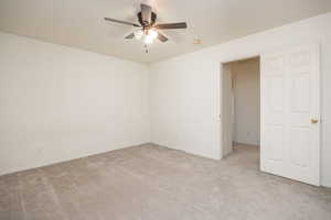 Carpeted empty room with ceiling fan