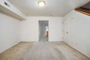 Unfurnished room with light colored carpet and a textured ceiling