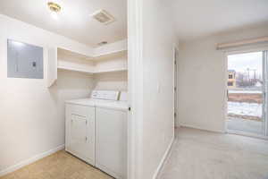 Laundry room featuring electric panel and independent washer and dryer