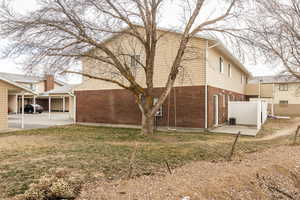 Exterior space featuring a carport, a lawn, and central AC