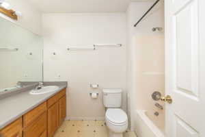 Full bathroom with toilet, washtub / shower combination, and vanity