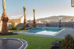 View of pool with a mountain view and a yard