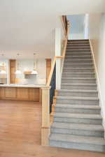 Stairs featuring sink and hardwood / wood-style flooring