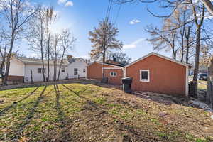 Back of house with central air condition unit and a lawn