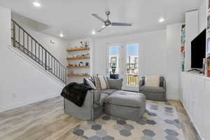 Living room with a ceiling fan and wood floating shelves