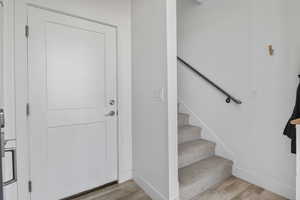 Foyer showing the door to the garage and a flight of stairs up to the first level