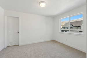 Unfurnished room with light carpet