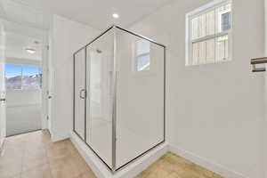 Bathroom featuring a shower with shower door and tile patterned flooring