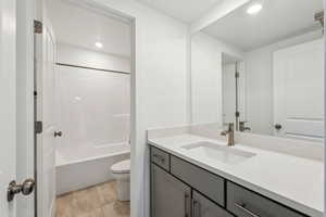 Full bathroom with toilet, vanity, tile patterned flooring, and shower / bath combination