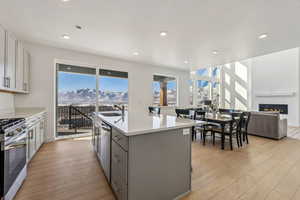 Kitchen with a mountain view, an island with sink, appliances with https://www.utahrealestate.com/lip.wizard/run/step/2/hbid/4915098#stainless steel finishes, gray cabinetry, and sink