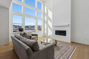 Living room with a towering ceiling, a mountain view, and light hardwood / wood-style floors