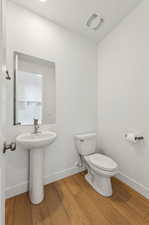 Bathroom with hardwood / wood-style flooring and toilet