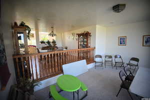 Interior space with a textured ceiling, an inviting chandelier, and carpet floors