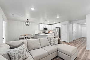 Living room featuring light hardwood / wood-style floors and a chandelier