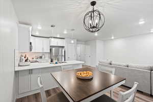 Dining space with light wood-type flooring, sink, and a chandelier