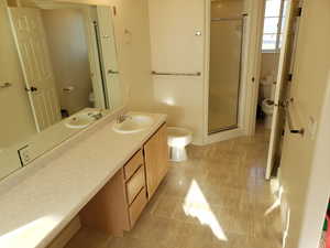 Bathroom with toilet, walk in shower, a bidet, and vanity