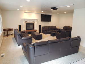 Carpeted living room featuring a tiled fireplace