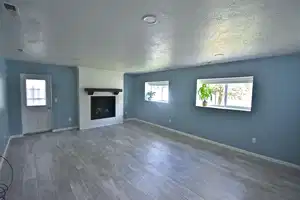 Unfurnished living room featuring a textured ceiling, a fireplace, and hardwood / wood-style floors