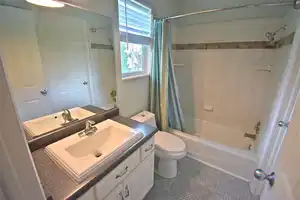 Full bathroom with toilet, vanity, and shower / bath combo