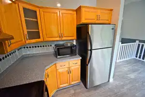 Kitchen featuring backsplash, stainless steel fridge, and electric range