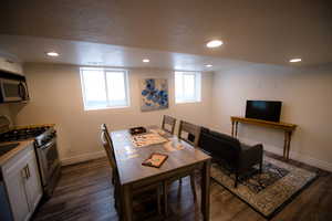 Dining area with dark wood-type flooring