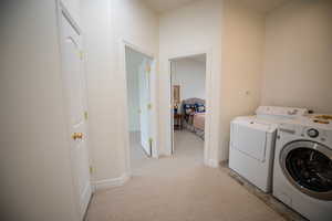 Clothes washing area with light carpet and washing machine and clothes dryer