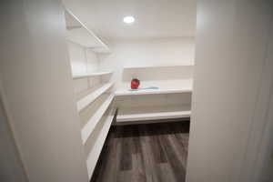 Walk in closet featuring built in desk and wood-type flooring