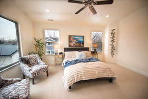 Bedroom with ceiling fan and light colored carpet